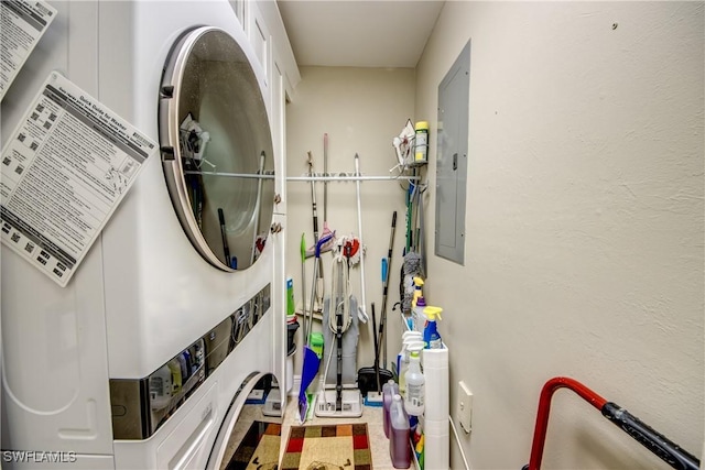 laundry room featuring stacked washer / dryer and electric panel