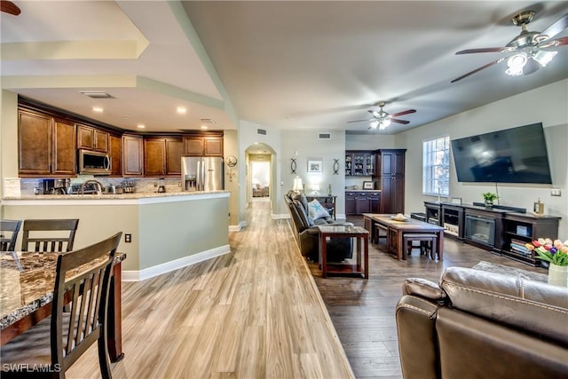 living room with ceiling fan and light hardwood / wood-style flooring