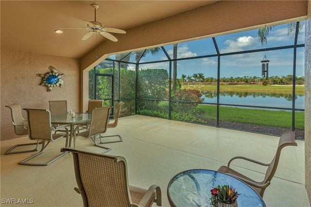 sunroom featuring ceiling fan and a water view