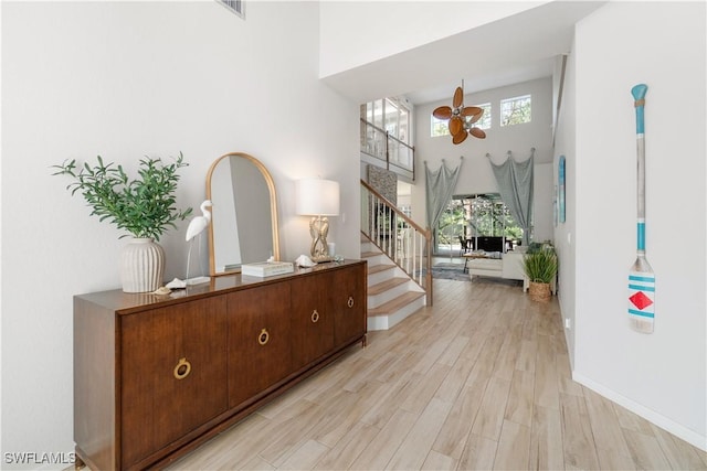 15881 Delasol Ln, Naples, FL 34110 - entryway featuring a ceiling fan, stairway, light wood-type flooring, a high ceiling, and baseboards