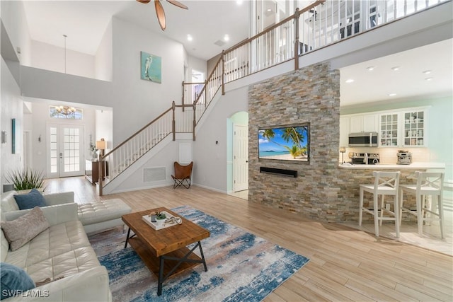 15881 Delasol Ln, Naples, FL 34110 - living room featuring a high ceiling, stairway, wood finished floors, a chandelier, and ceiling fan