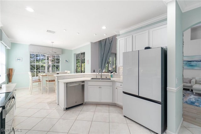 15881 Delasol Ln, Naples, FL 34110 - kitchen featuring stainless steel appliances, a sink, white cabinets, crown molding, and a peninsula