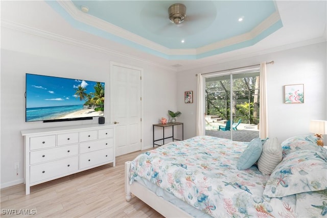 bedroom featuring light wood finished floors, a tray ceiling, access to exterior, a ceiling fan, and ornamental molding