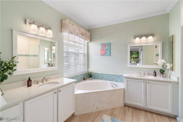 full bath with two vanities, a garden tub, crown molding, and a sink