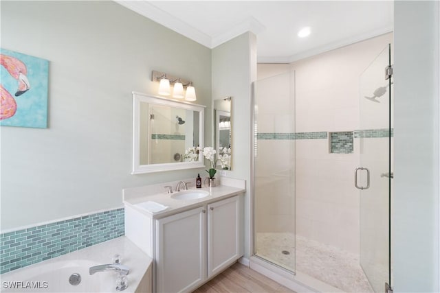 bathroom featuring a bath, vanity, a shower stall, and crown molding