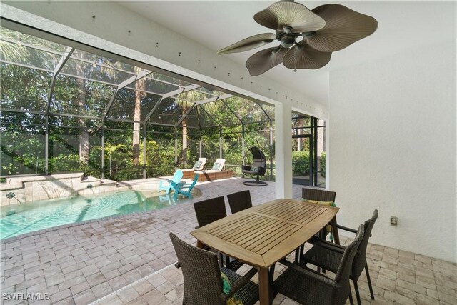 view of patio / terrace with a ceiling fan, a lanai, and an outdoor pool