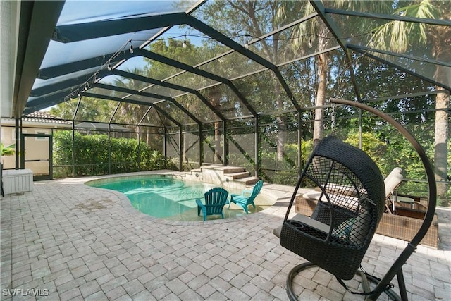 pool with glass enclosure and a patio