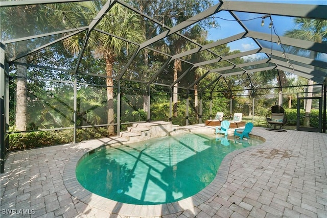 outdoor pool featuring a patio area and a lanai