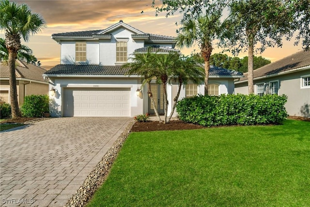 15881 Delasol Ln, Naples, FL 34110 - view of front of home with decorative driveway, stucco siding, a yard, a garage, and a tiled roof