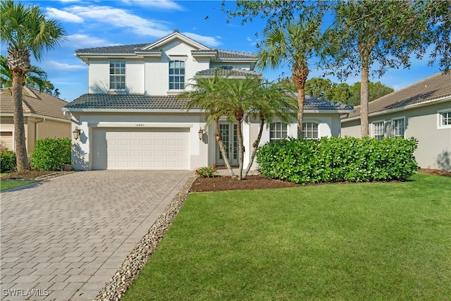 traditional-style home with an attached garage, a front lawn, stucco siding, and decorative driveway