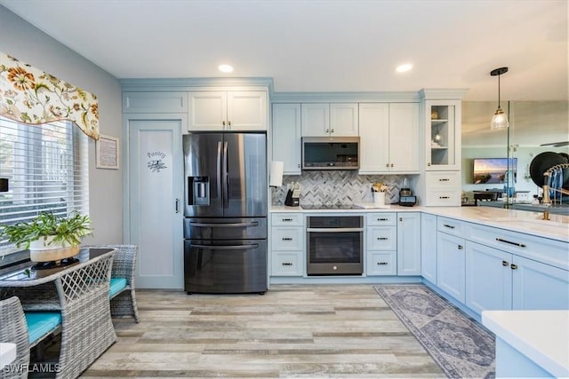 4572 Andover Way Unit C102, Naples, FL 34112 - kitchen featuring light countertops, appliances with stainless steel finishes, hanging light fixtures, and decorative backsplash