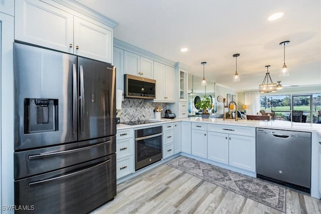 4572 Andover Way Unit C102, Naples, FL 34112 - kitchen featuring white cabinetry, light countertops, stainless steel appliances, and pendant lighting