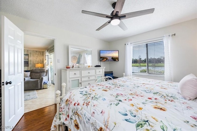 4572 Andover Way Unit C102, Naples, FL 34112 - bedroom featuring a ceiling fan, light wood-style floors, and a textured ceiling