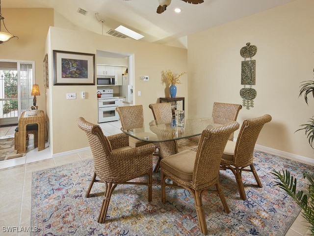 dining area with ceiling fan, lofted ceiling, and light tile patterned floors