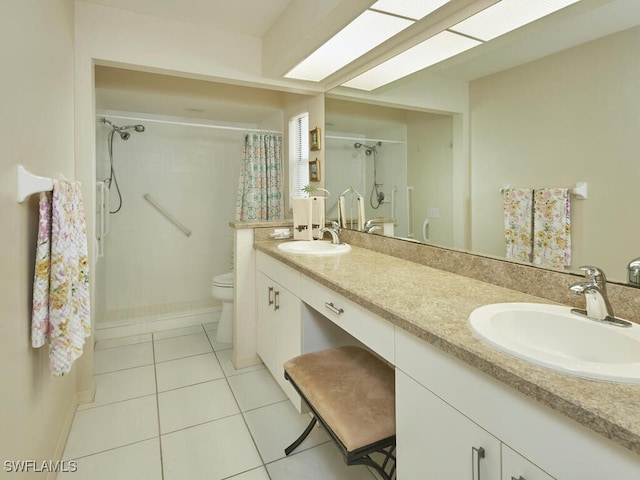 bathroom with a skylight, vanity, toilet, tile patterned floors, and a shower with curtain