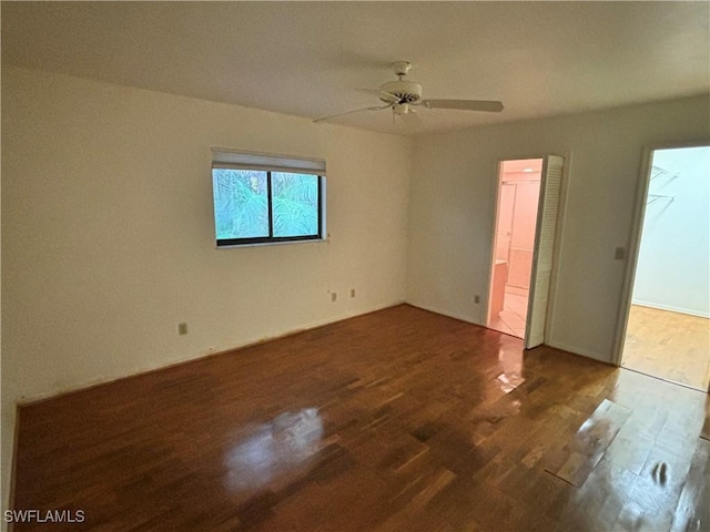 empty room with ceiling fan and dark hardwood / wood-style floors