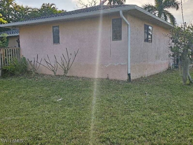 view of side of home with a yard