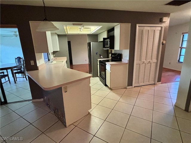 kitchen featuring pendant lighting, light tile patterned floors, white cabinetry, black range with electric cooktop, and kitchen peninsula