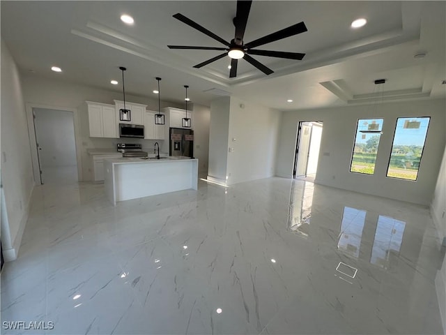 unfurnished living room featuring ceiling fan, a raised ceiling, and sink