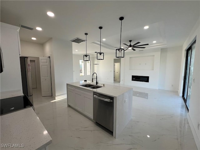 kitchen featuring sink, appliances with stainless steel finishes, an island with sink, pendant lighting, and white cabinets