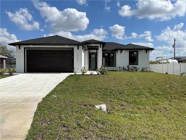 prairie-style house featuring a garage and a front yard