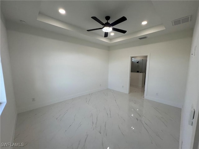 unfurnished room featuring a tray ceiling and ceiling fan