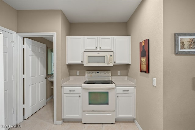 kitchen with white appliances, light tile patterned floors, and white cabinets