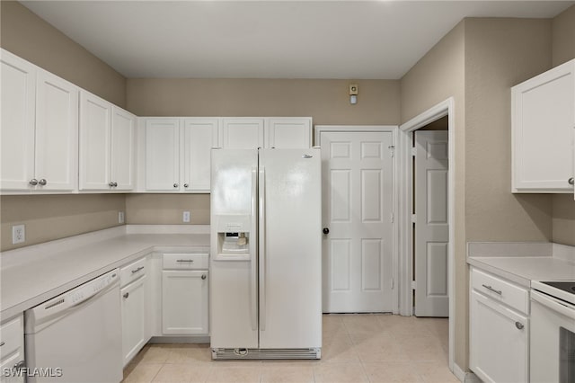 kitchen with white appliances, light tile patterned floors, and white cabinets