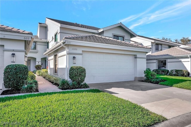 view of front of home with a garage, concrete driveway, a front lawn, and stucco siding