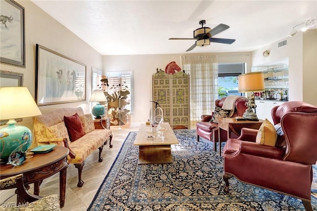 living room with light tile patterned floors, visible vents, and a ceiling fan