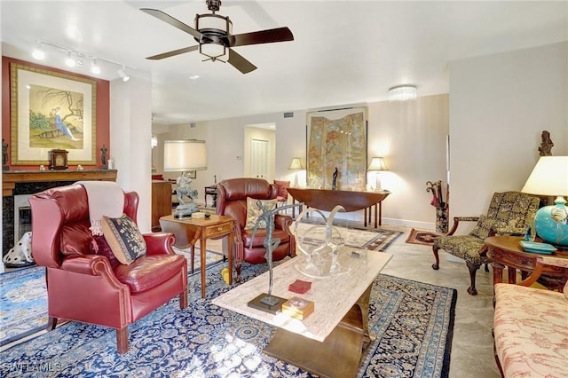 living area featuring light tile patterned floors, visible vents, baseboards, a ceiling fan, and rail lighting