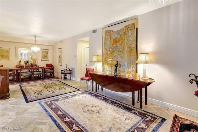 living area featuring an inviting chandelier, visible vents, and baseboards