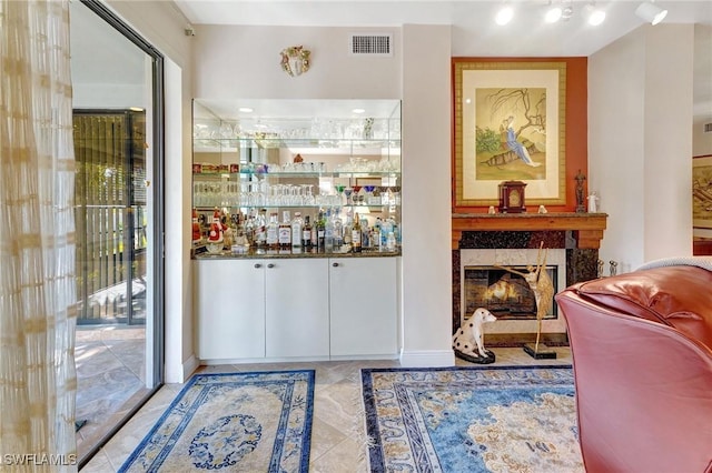 bar featuring visible vents and a tiled fireplace