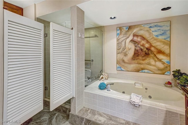 bathroom with a tub with jets and a shower stall