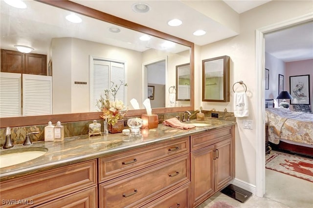 ensuite bathroom featuring ensuite bathroom, double vanity, a sink, and recessed lighting