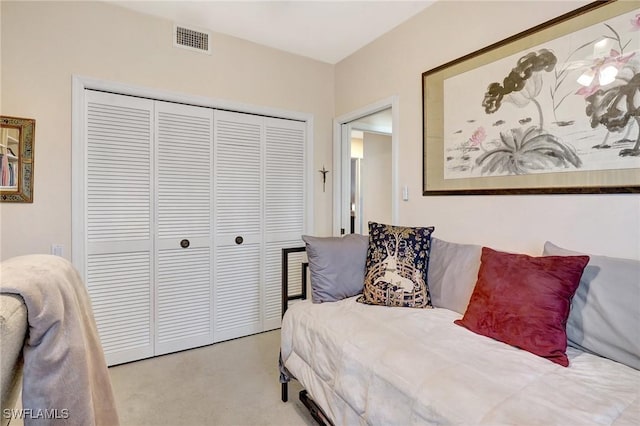 bedroom featuring visible vents, a closet, and light colored carpet