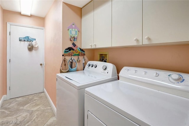 laundry area with cabinet space, baseboards, and separate washer and dryer