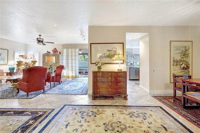 interior space with a ceiling fan and baseboards