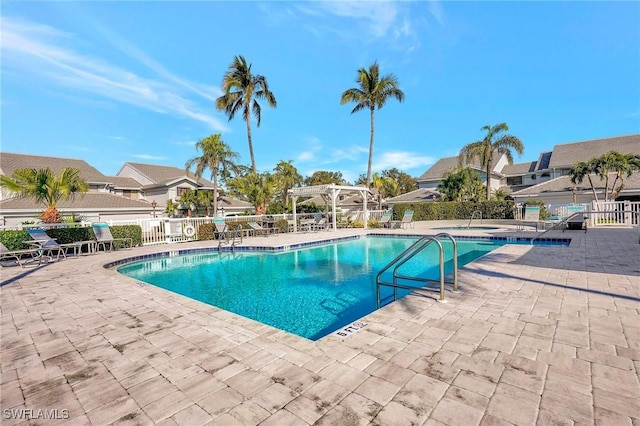 pool featuring a patio, fence, a residential view, and a pergola