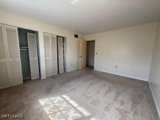 unfurnished bedroom featuring two closets