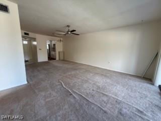 unfurnished living room with dark colored carpet and ceiling fan