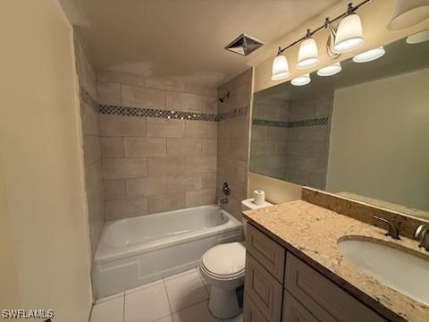 full bathroom with tiled shower / bath, vanity, tile patterned floors, and toilet