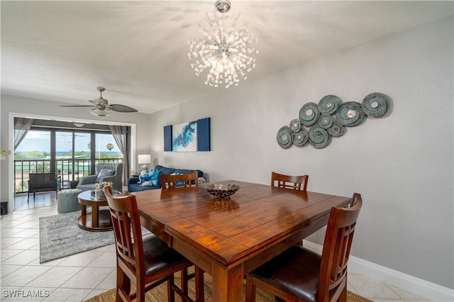 tiled dining area featuring ceiling fan with notable chandelier