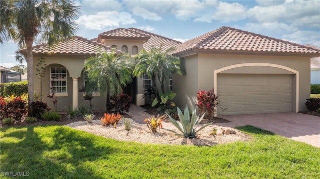 mediterranean / spanish-style home with an attached garage, a front lawn, decorative driveway, and stucco siding