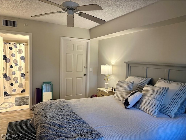 bedroom featuring wood-type flooring, connected bathroom, ceiling fan, and a textured ceiling