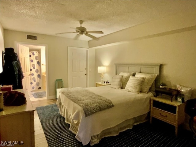 bedroom with ceiling fan, ensuite bathroom, hardwood / wood-style floors, and a textured ceiling