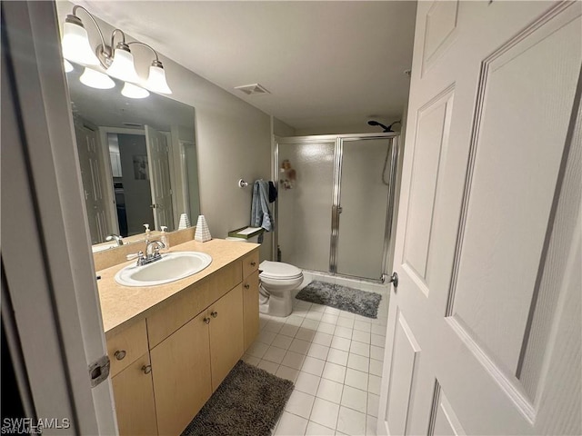 bathroom with tile patterned flooring, vanity, a shower with door, and toilet