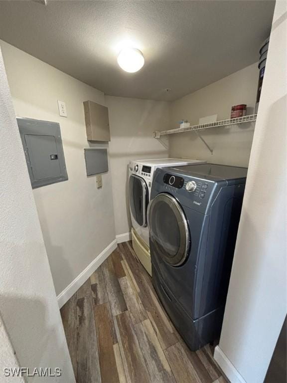 washroom featuring washing machine and dryer, laundry area, electric panel, and dark wood finished floors