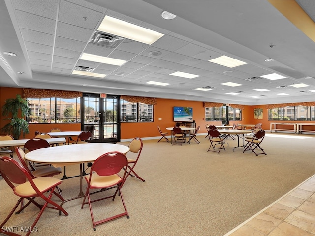 dining area featuring french doors, carpet flooring, and a drop ceiling