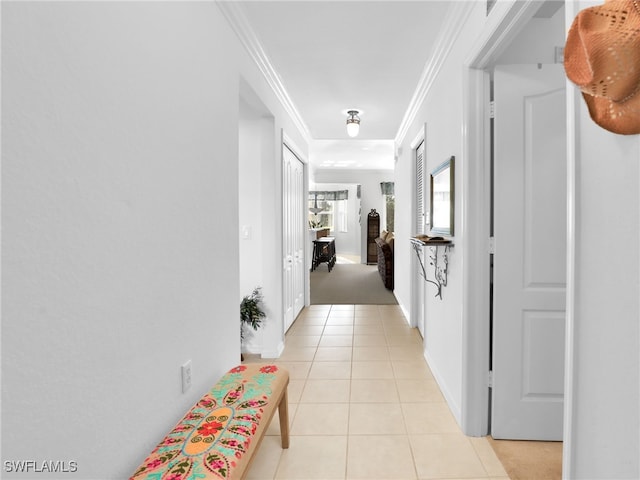 hallway featuring crown molding and light tile patterned floors